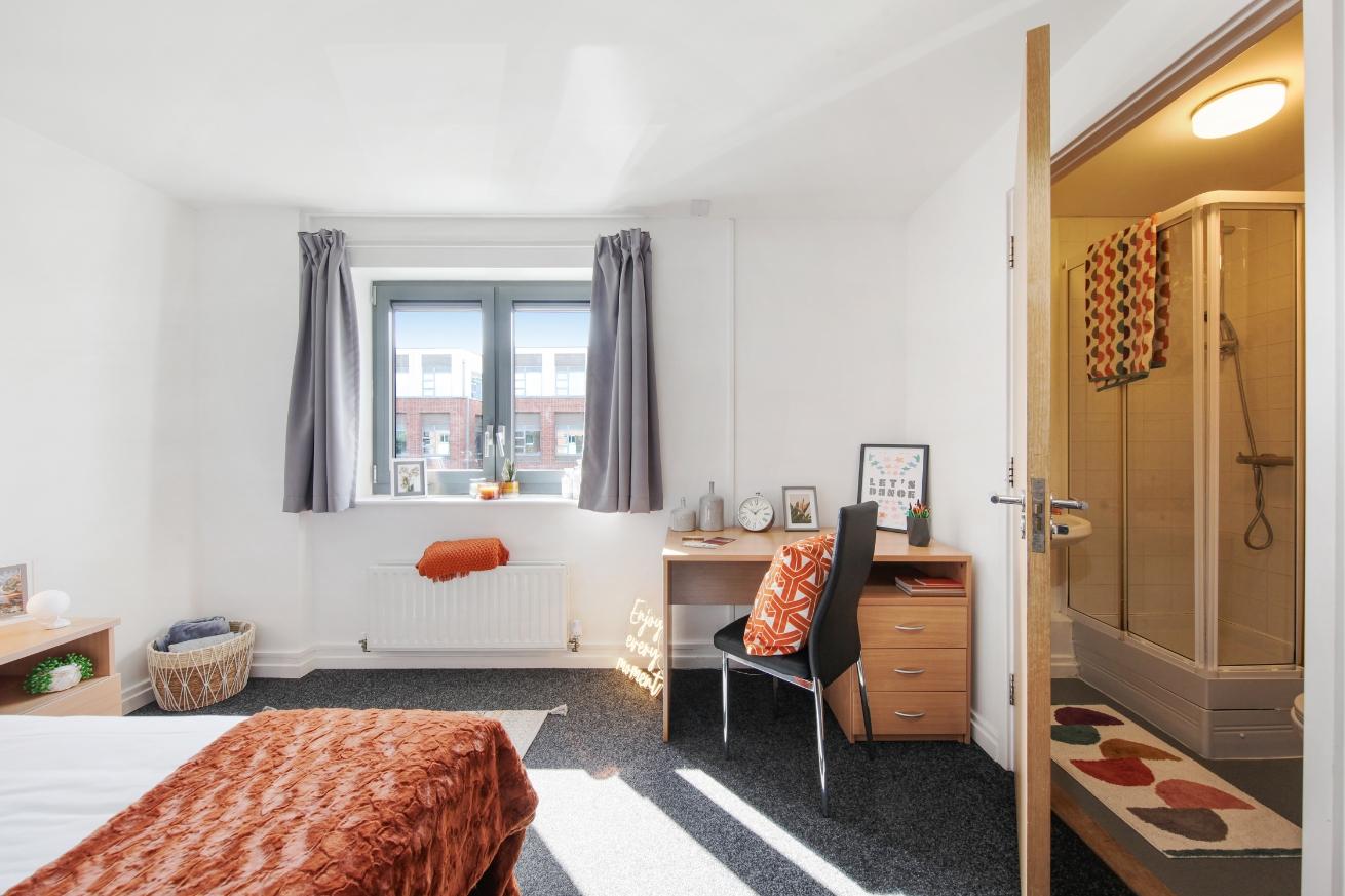 A double bedroom showing double bed, desk and entrance into the en-suite 